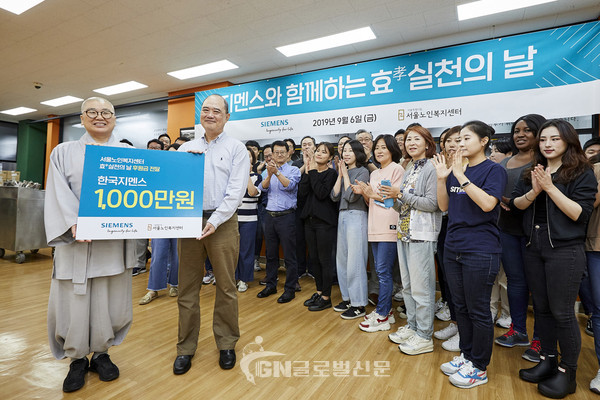 한국지멘스 더 나눔 봉사단이 서울 종로구 서울노인복지센터를 찾아 후원금 1000만원을 전달하고 있다