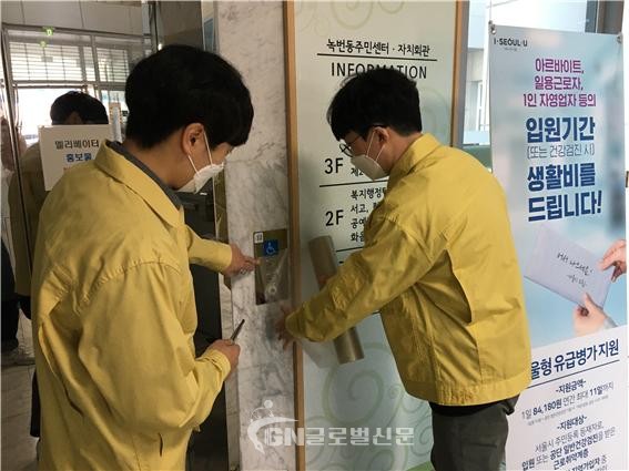 은평구 관계자들이 항균필터를 녹번동 주민센터 엘리베이터에 부착하는 모습