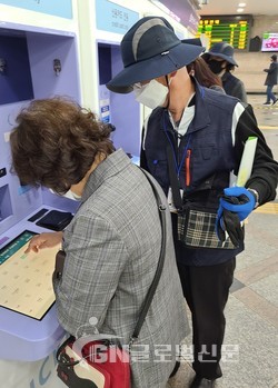 영등포역에서 자동발매기 사용방법을 안내하고 있는 시니어클럽 어르신(왼쪽)
