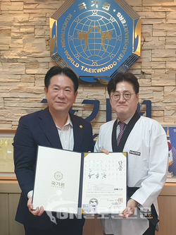 태권도 명예 7단증을 받은 홍익표 국회 문화체육관광위원장(오른쪽)이 이동섭 국기원장과 포즈를 취했다.(사진제공 국기원)