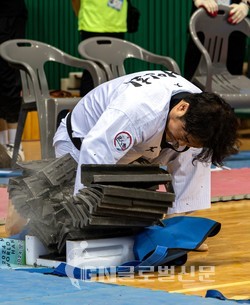 경상북도 문경시에서 열리고 있는 ‘2024 문경 세계태권도한마당’ 셋째 날인 7월 28일 국내 주먹격파 시니어 Ⅲ 부문에서 정상민 사범이 우승했다. 사진은 정 사범이 기왓장을 완파한 모습.