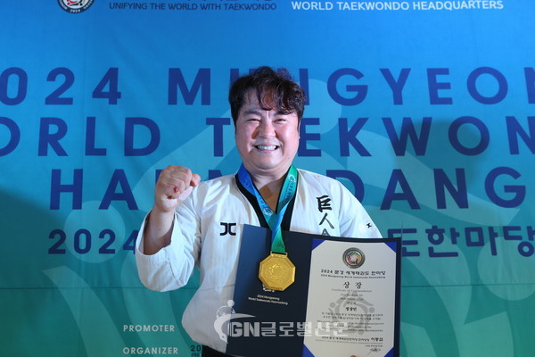 주먹격파 시니어 Ⅲ 우승자인 정상민 사범이 메달과 상장을 받은 뒤 주먹을 불끈쥐며 기념사진 촬영을 했다.