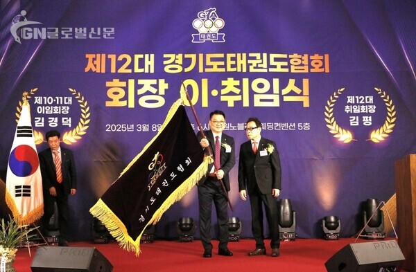 사진-협회기를 이양 받은 경기도태권도협회 신임 회장 김평(좌측)과 협회기를 이양한 김경덕 회장(우측)